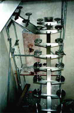 Spindeltreppe mit runden Trittplatten aus Edelstahl während der Montage, an einem Gerüst.