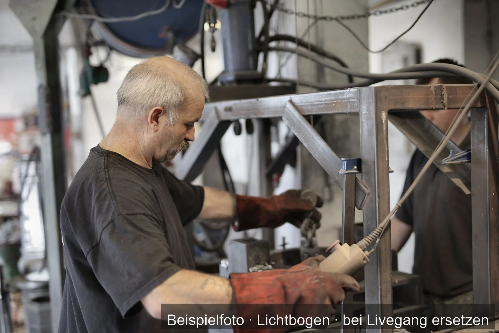 Zwei Metallbauer arbeiten gemeinsam an einem Stahlrahmen.